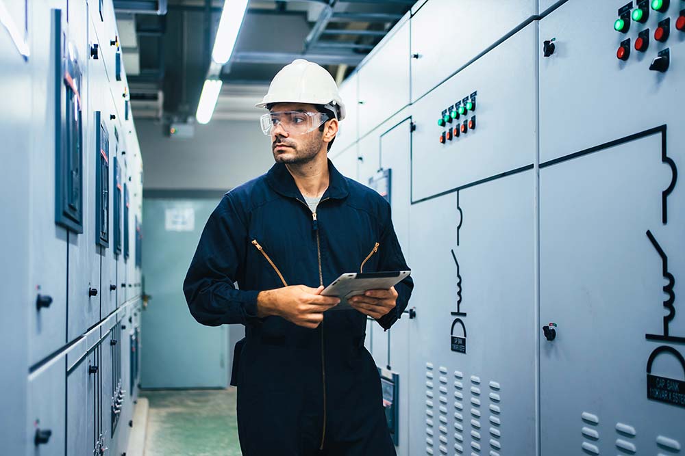 Engineer inspecting electrical panels supporting critical power equipment insulation reliability